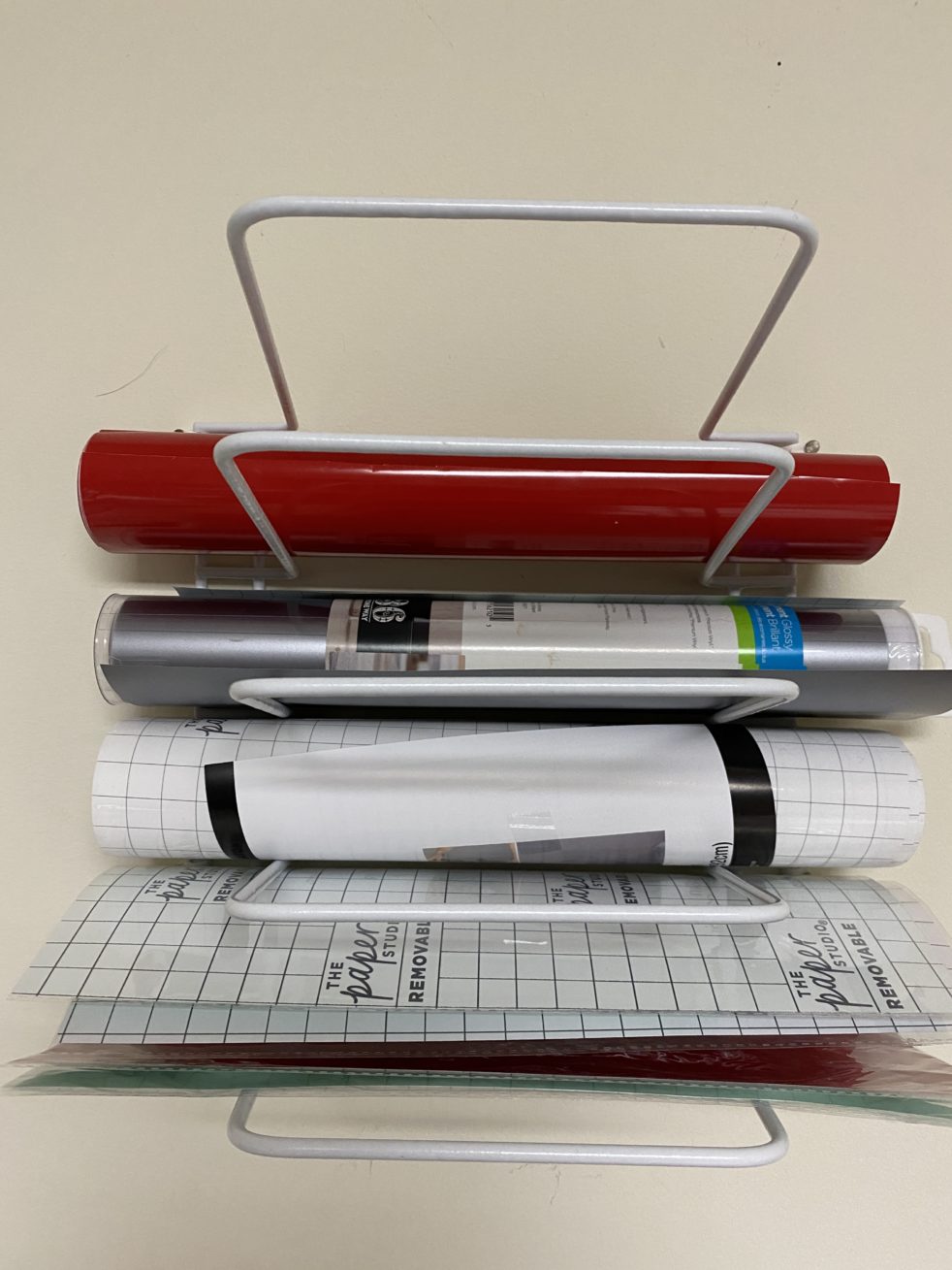 Cheap DIY Wall Vinyl Holder - here is a cheap way to hang up and store your vinyl rolls. #Vinyl #Cricut #DIY